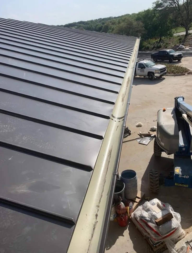 Standing seam panel and gutter detail on a metal roofing jobsite in Cape Coral